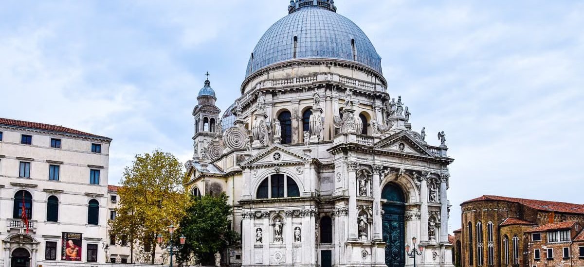 Front view of Santa Maria della Salute basilica in Venice with gondolas in the foreground.