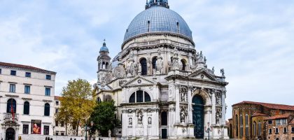 Front view of Santa Maria della Salute basilica in Venice with gondolas in the foreground.