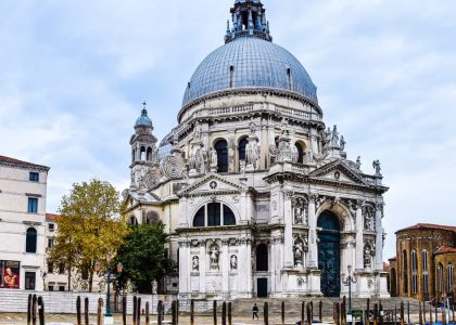 Front view of Santa Maria della Salute basilica in Venice with gondolas in the foreground.