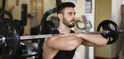 A focused man lifting weights indoors showcasing strength and concentration.