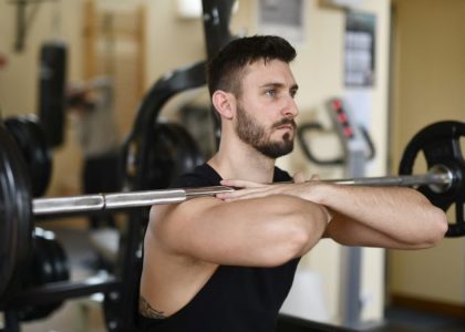 A focused man lifting weights indoors showcasing strength and concentration.